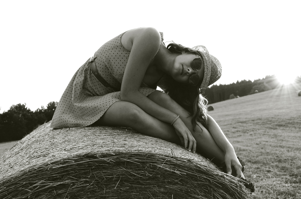 A beautiful girl on a posing in black and white on a harvested field